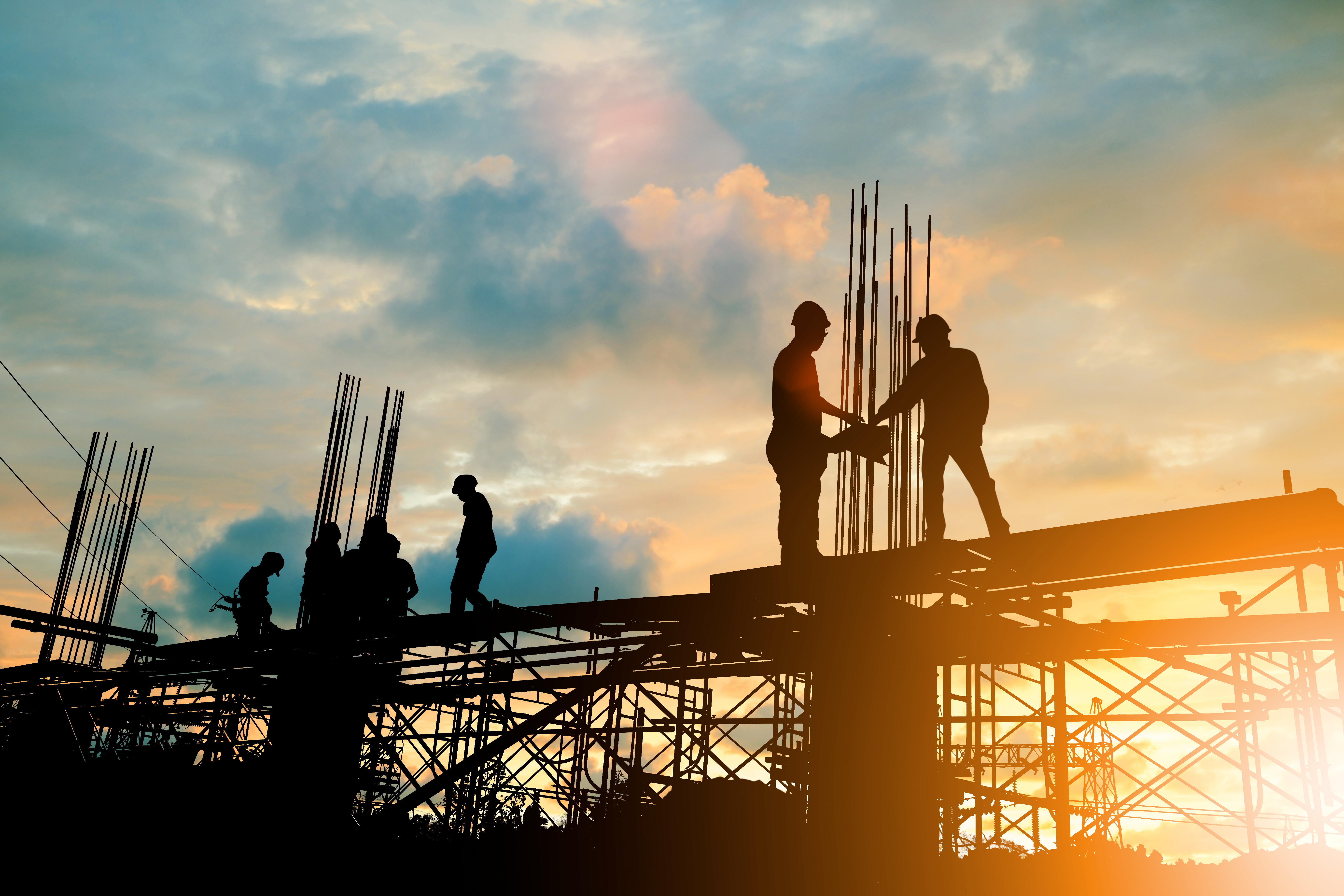 Silhouette of engineer and construction team working at site ove